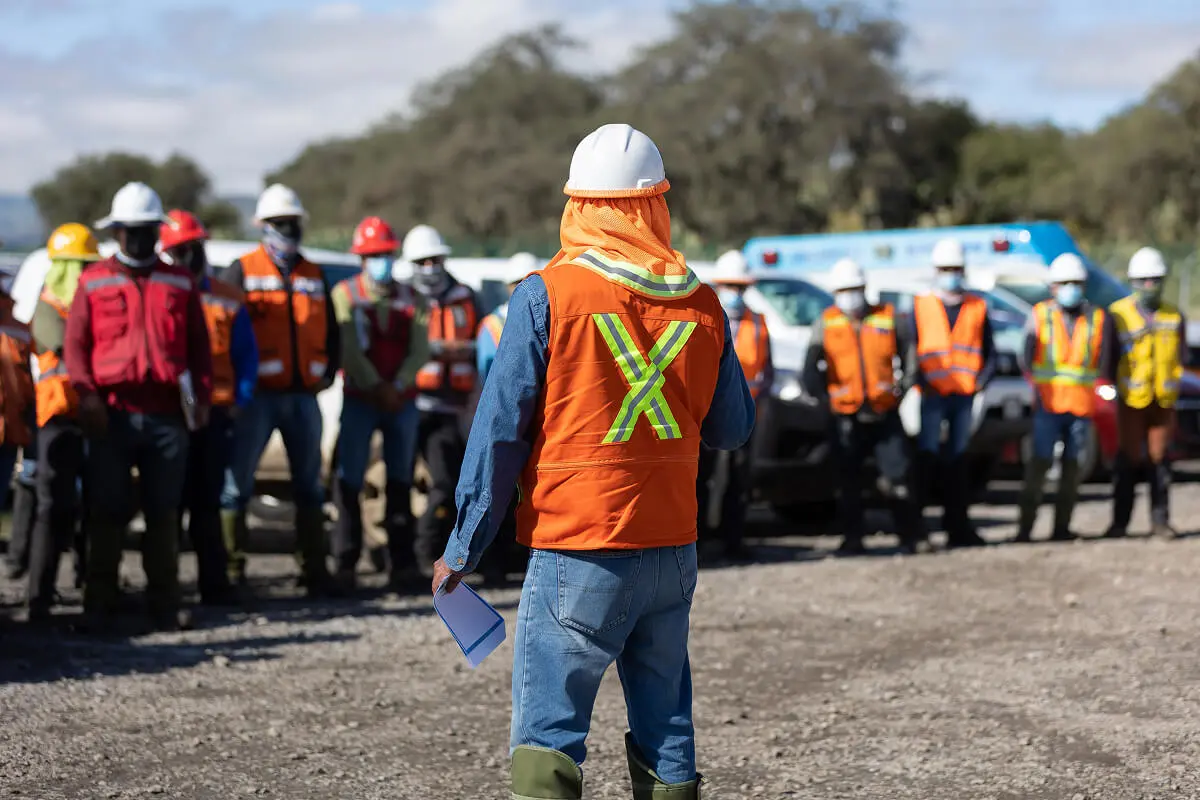 Construction workers gathered for outdoor meeting.