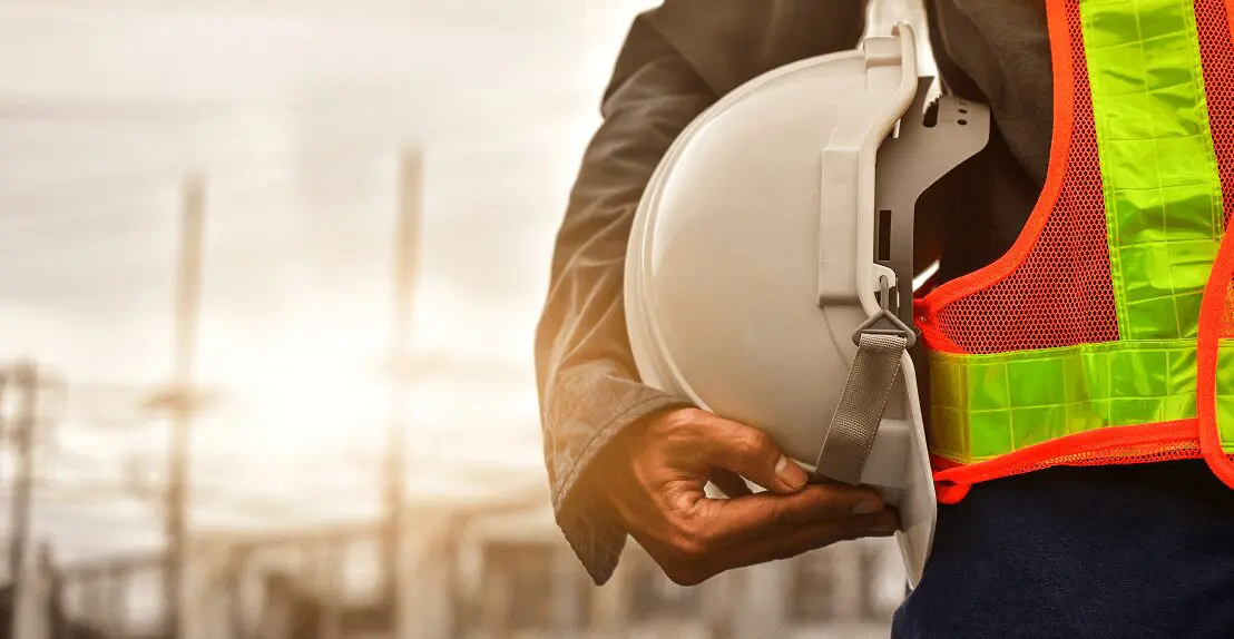 Construction worker holding a white hard hat.