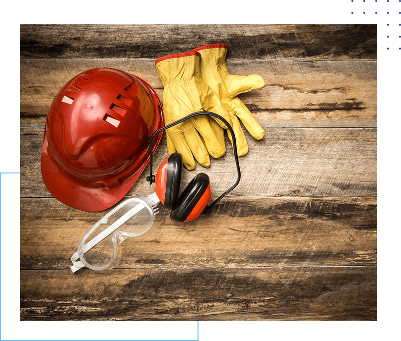 A hard hat, ear muffs and gloves on top of a wooden table.