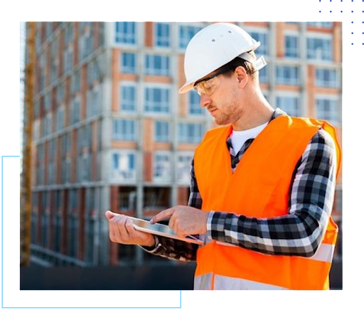 A man in an orange vest and hard hat holding a tablet.
